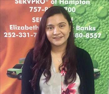 female office employee in front of SERVPRO sign